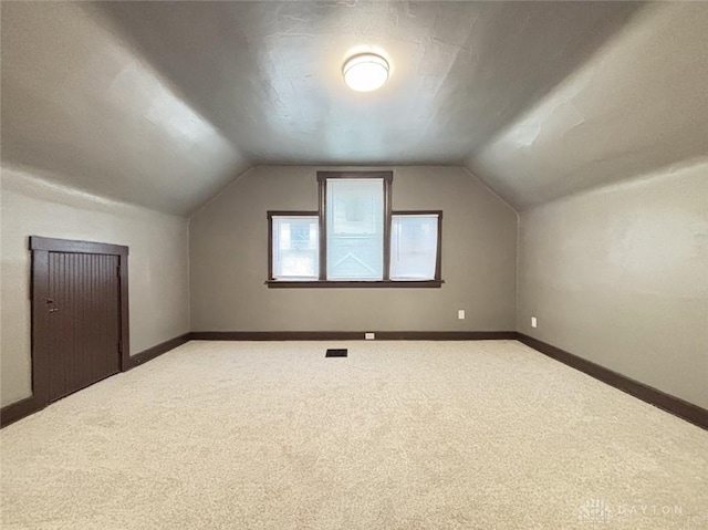 bonus room featuring lofted ceiling and carpet floors