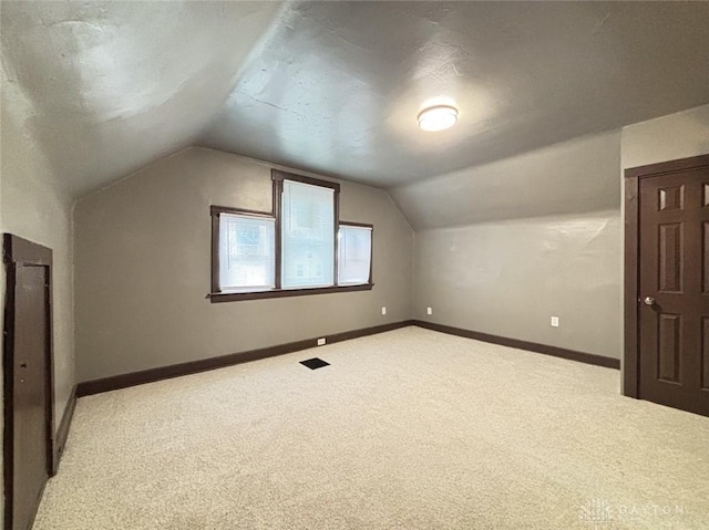 bonus room with carpet floors and vaulted ceiling