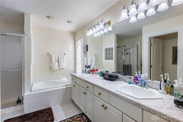 bathroom with tile patterned floors, vanity, separate shower and tub, and a textured ceiling