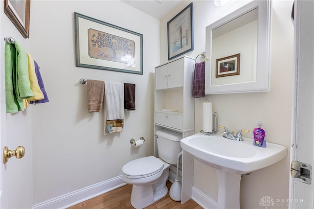 bathroom featuring hardwood / wood-style flooring and toilet