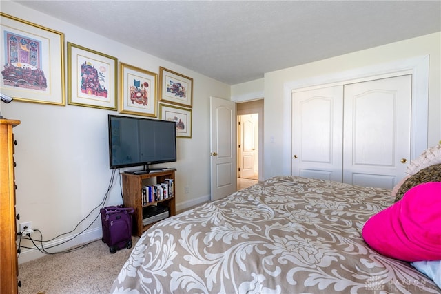 carpeted bedroom featuring a textured ceiling and a closet