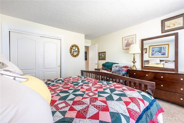 bedroom featuring a textured ceiling, light colored carpet, and a closet