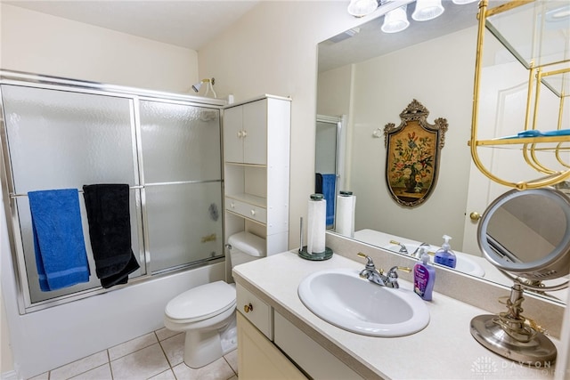 full bathroom with tile patterned floors, toilet, vanity, and combined bath / shower with glass door