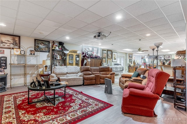 living room with ceiling fan, hardwood / wood-style floors, and a drop ceiling