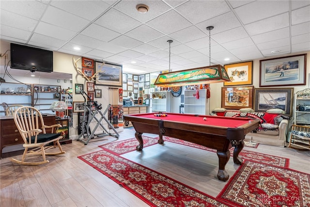 rec room with pool table, a drop ceiling, and hardwood / wood-style flooring