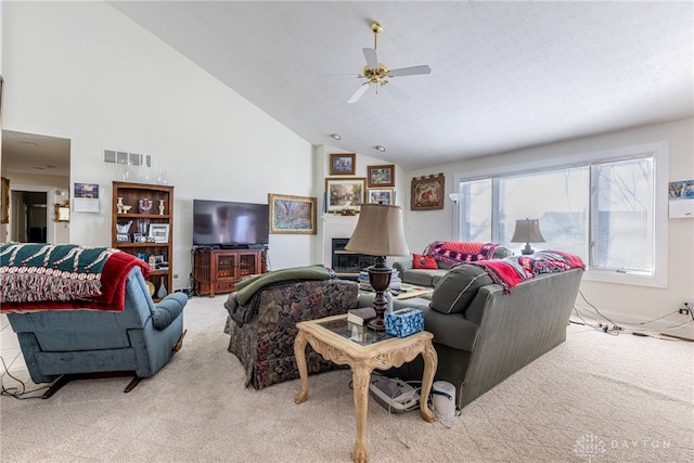 carpeted living room with a textured ceiling, high vaulted ceiling, and ceiling fan