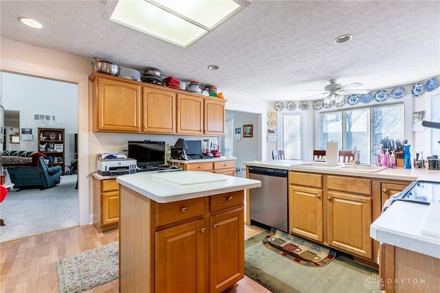 kitchen with stainless steel dishwasher, a textured ceiling, ceiling fan, sink, and light hardwood / wood-style floors