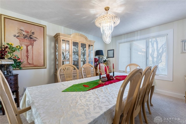 carpeted dining space with a textured ceiling and a notable chandelier