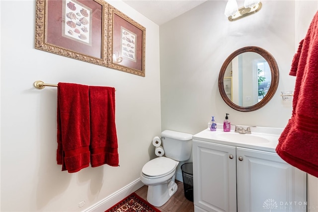 bathroom with vanity, toilet, and wood-type flooring