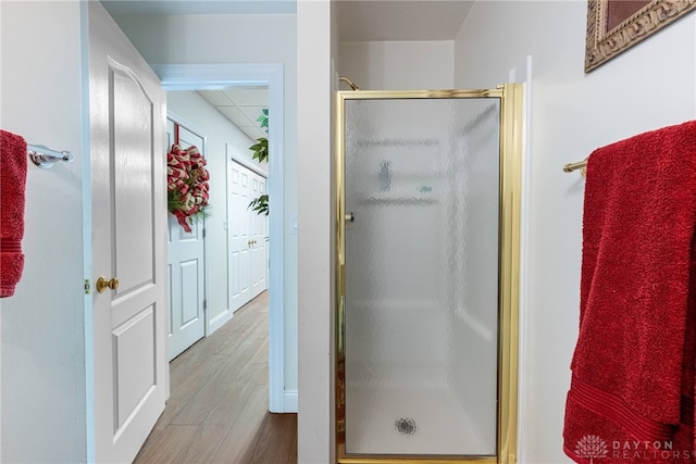 bathroom with hardwood / wood-style flooring and walk in shower