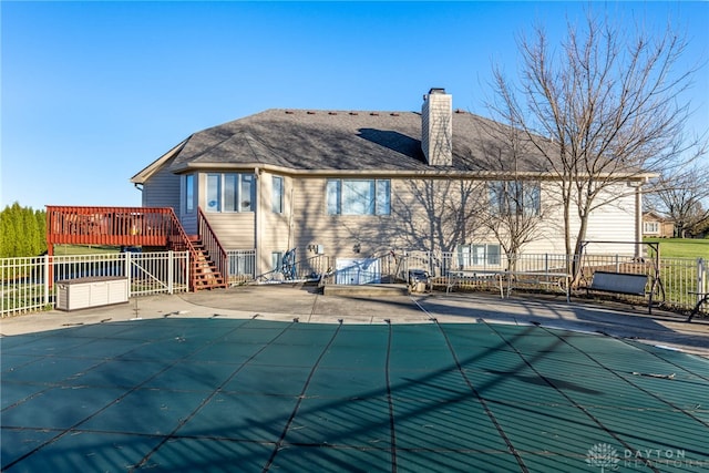 rear view of property with a swimming pool side deck and a patio area