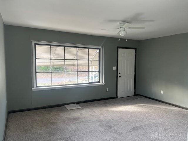 carpeted spare room with ceiling fan