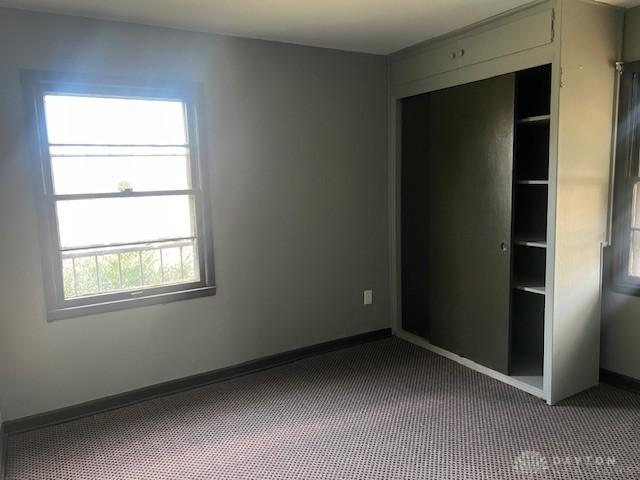 unfurnished bedroom featuring carpet flooring and a closet