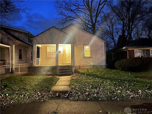 view of front of home with covered porch and a front lawn