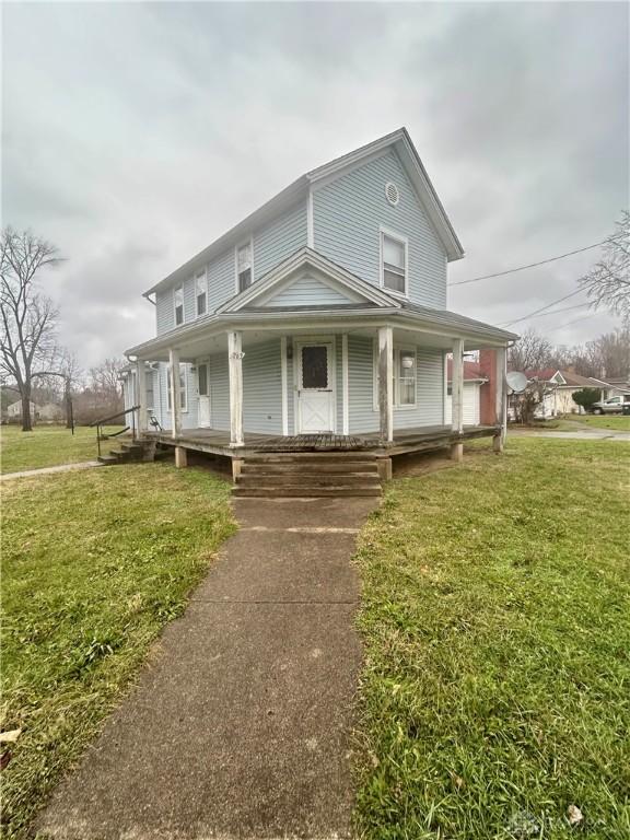 farmhouse featuring a front yard and covered porch