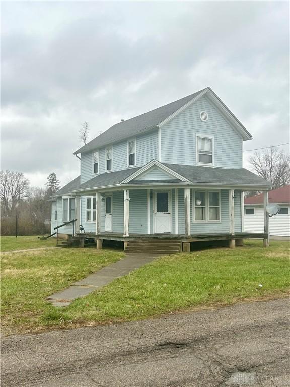 farmhouse inspired home with a front lawn