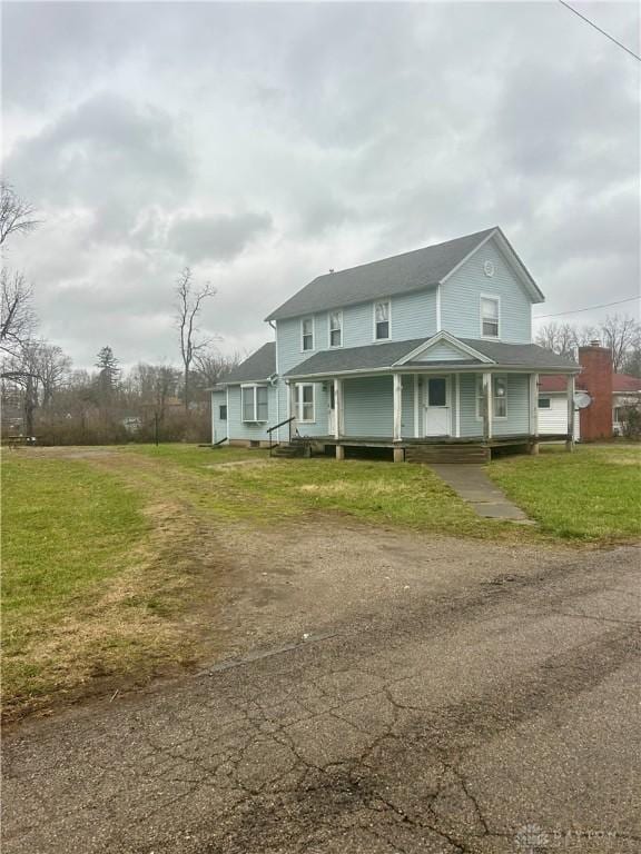 farmhouse inspired home with a front lawn