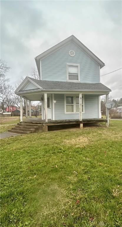 farmhouse-style home featuring a porch and a front lawn