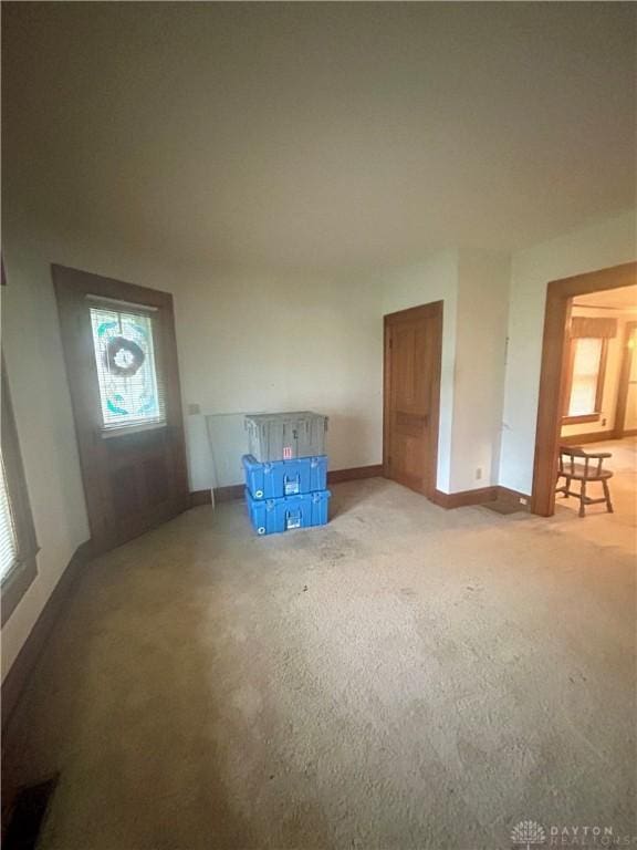 unfurnished room with carpet flooring and plenty of natural light