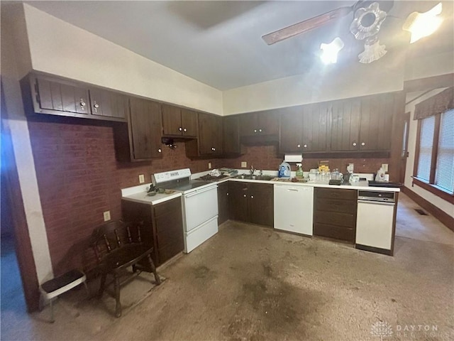 kitchen featuring brick wall, dark brown cabinets, white appliances, and sink