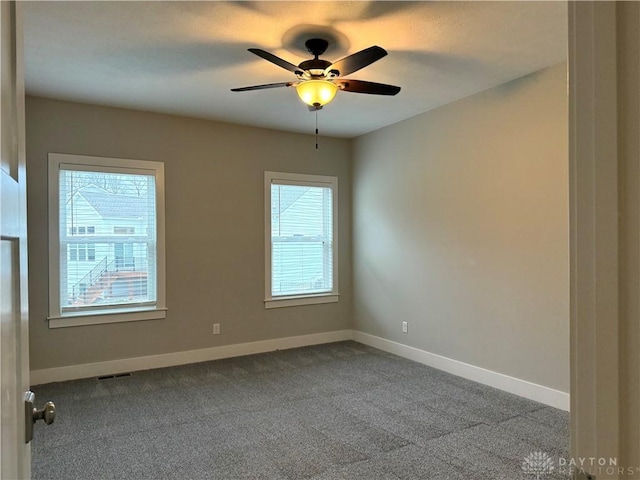 carpeted empty room featuring a wealth of natural light and ceiling fan