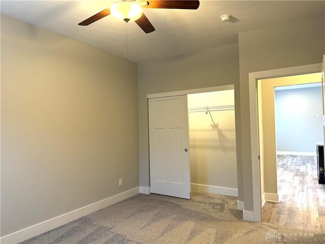 unfurnished bedroom featuring ceiling fan, light carpet, and a closet