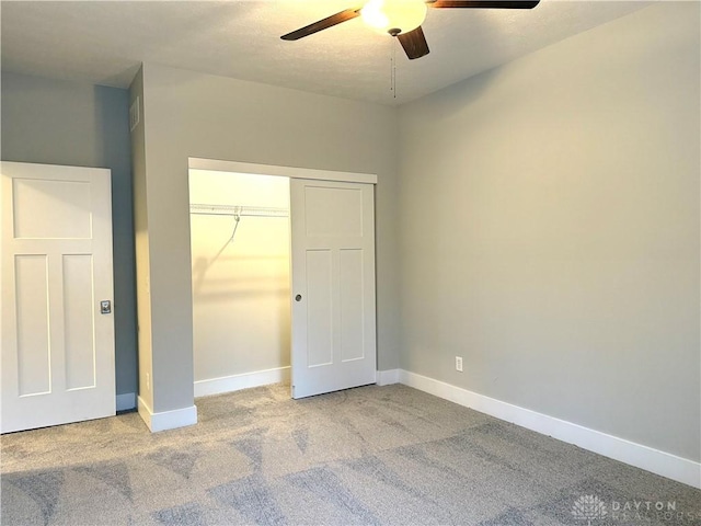 unfurnished bedroom featuring carpet flooring, ceiling fan, and a closet