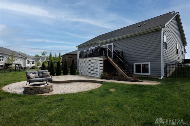 rear view of house featuring a yard, a fire pit, a deck, and a patio area