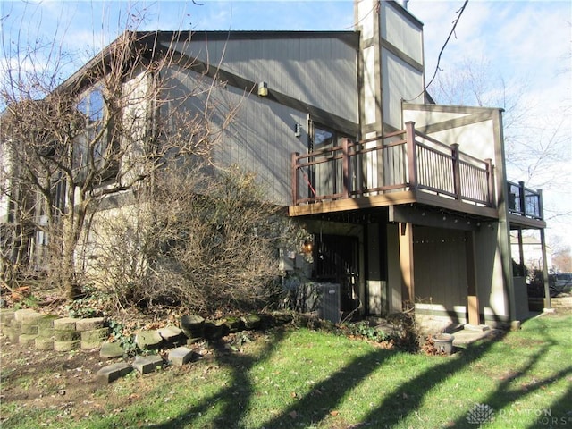 rear view of property with a lawn and a deck