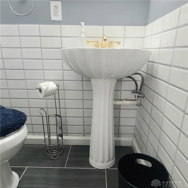 bathroom with tile walls and toilet