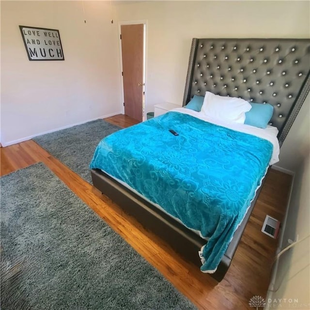 bedroom with dark hardwood / wood-style flooring