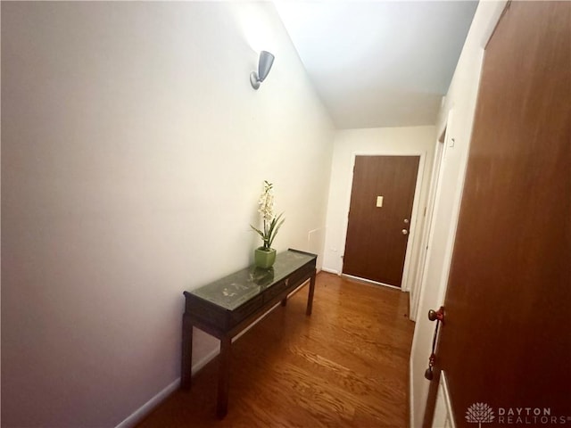 hallway with baseboards and wood finished floors
