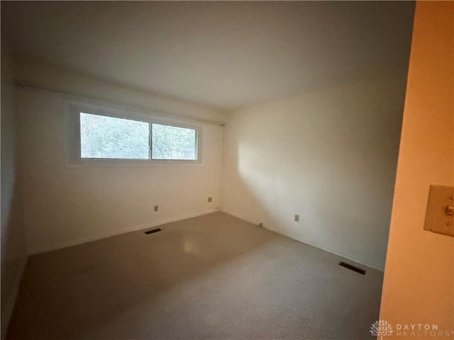 unfurnished room with carpet flooring and visible vents