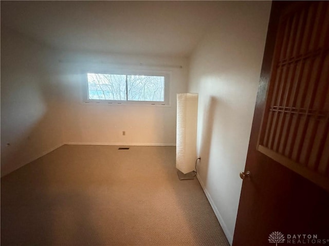 carpeted spare room featuring baseboards