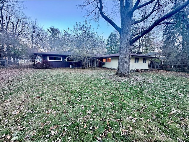 view of front facade with a front lawn and fence