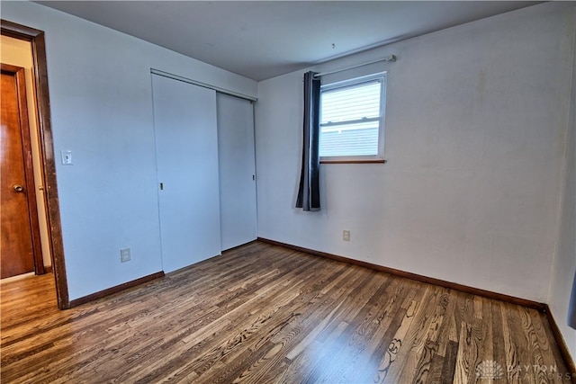 unfurnished bedroom featuring dark hardwood / wood-style flooring and a closet