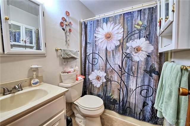 bathroom featuring a shower with shower curtain, vanity, and toilet