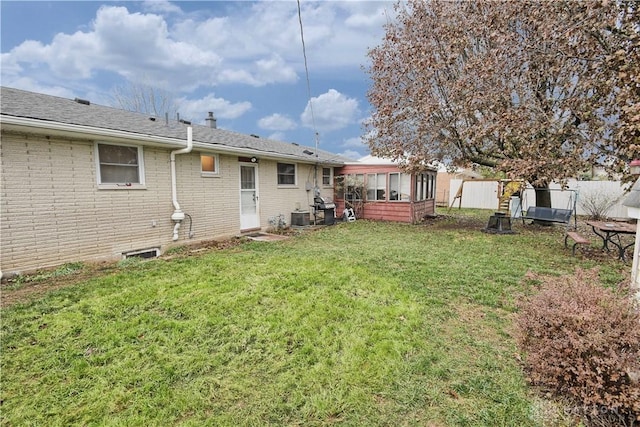 view of yard featuring a sunroom and central air condition unit