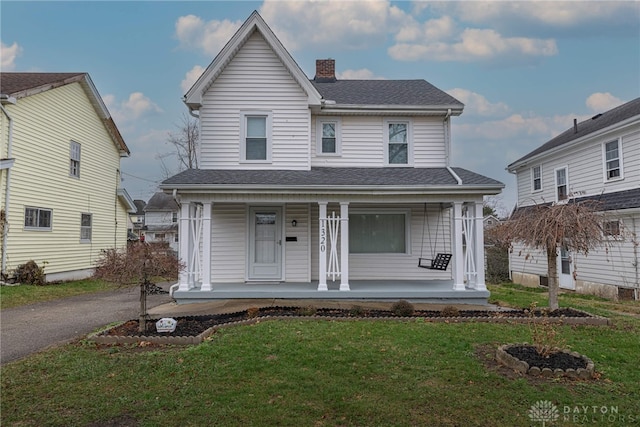 view of front facade with covered porch and a front yard