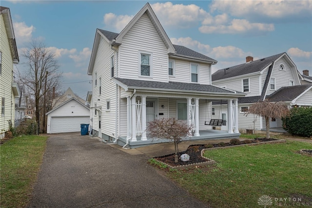 front of property with an outbuilding, a garage, a front lawn, and covered porch