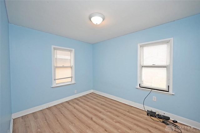 empty room with light wood-type flooring and plenty of natural light