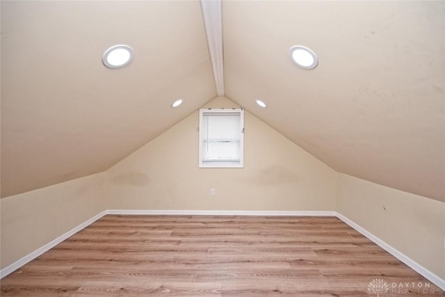 bonus room featuring lofted ceiling with beams and light wood-type flooring