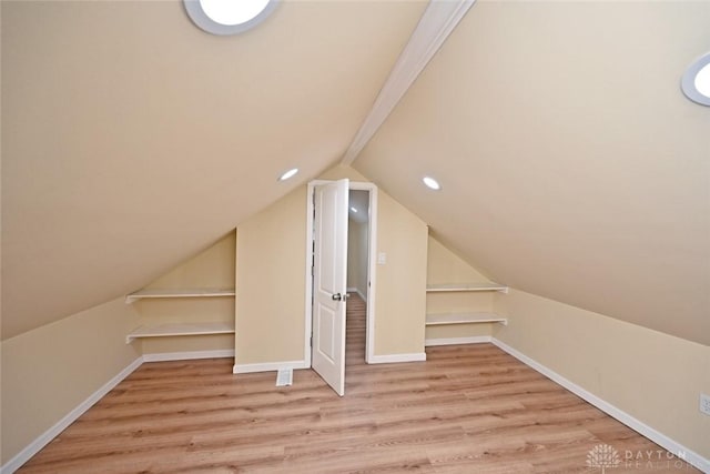 bonus room with light wood-type flooring and lofted ceiling