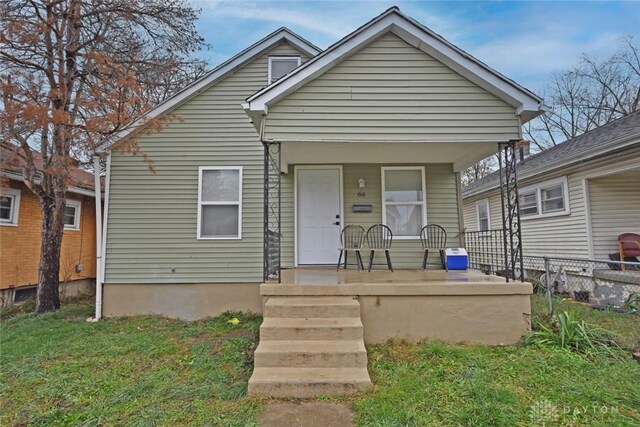 bungalow featuring covered porch and a front lawn