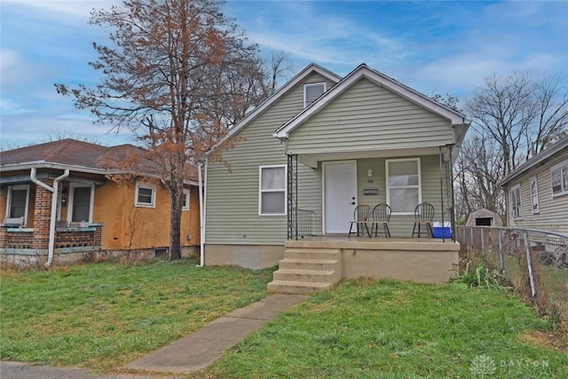 bungalow-style home with covered porch and a front lawn