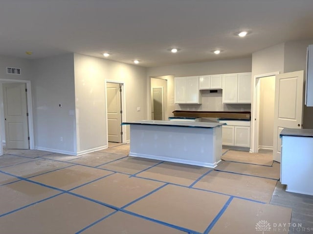 kitchen with a kitchen island and white cabinetry