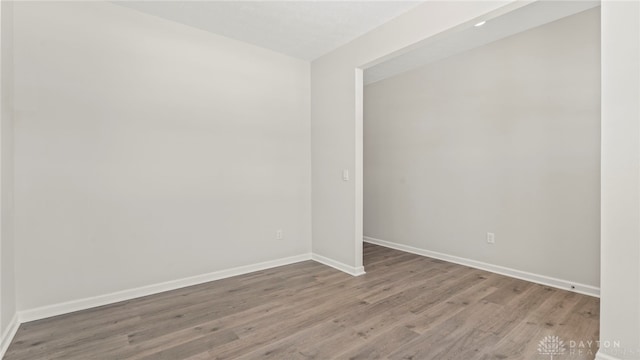 empty room featuring baseboards and wood finished floors