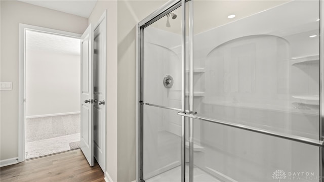 full bath featuring a shower stall and wood finished floors