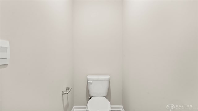 half bathroom with toilet and baseboards