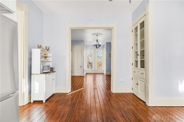 hall with a chandelier and wood-type flooring